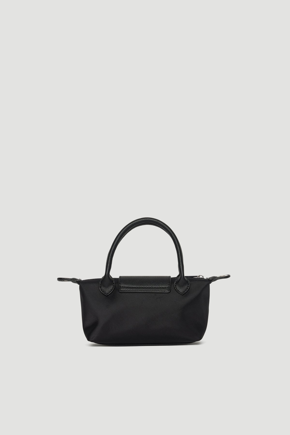 Black mini crossbody bag with top handles, silver hardware, and zip closure on plain light background