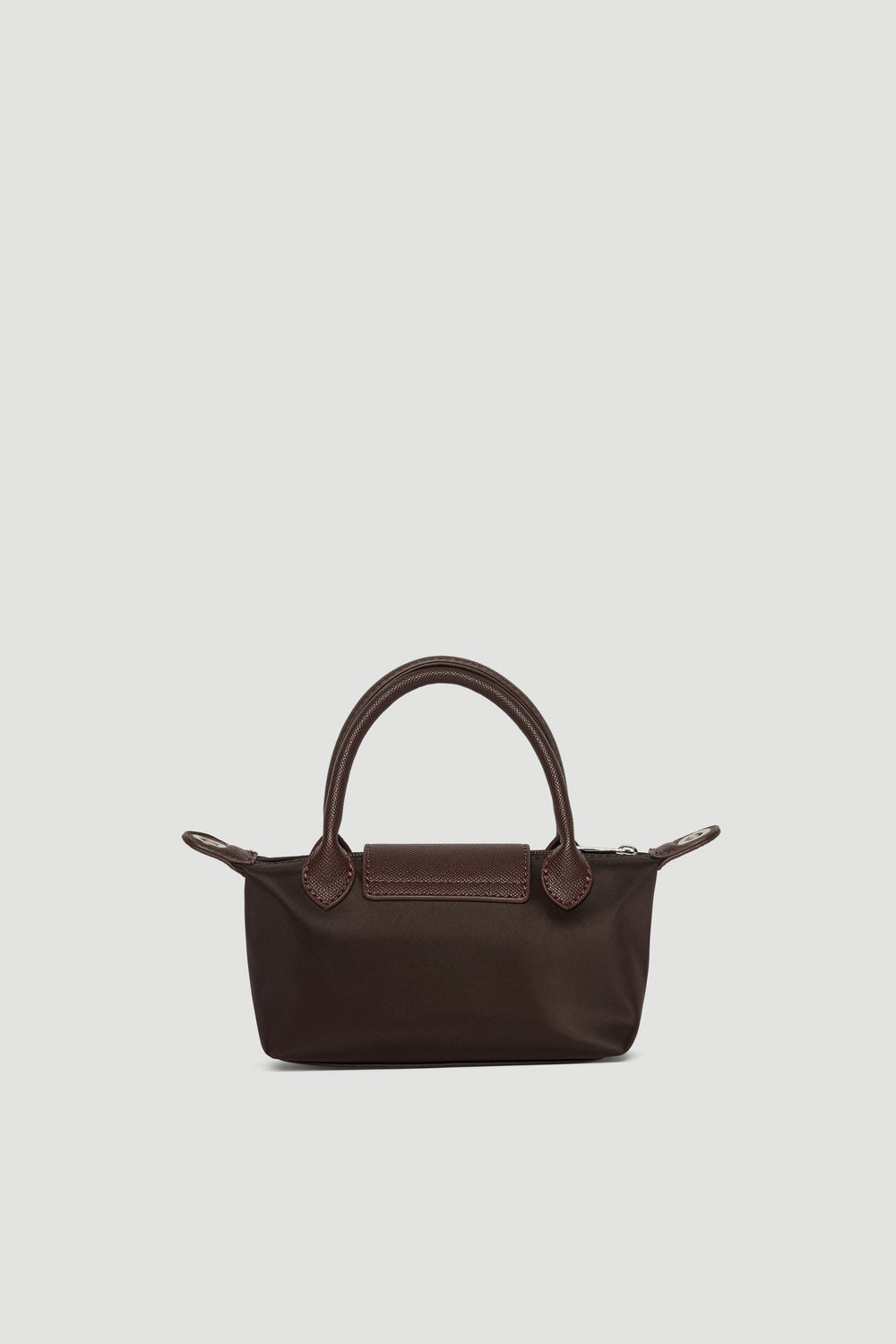 Small dark brown mini bag with double handles and silver zip closure shown against plain background