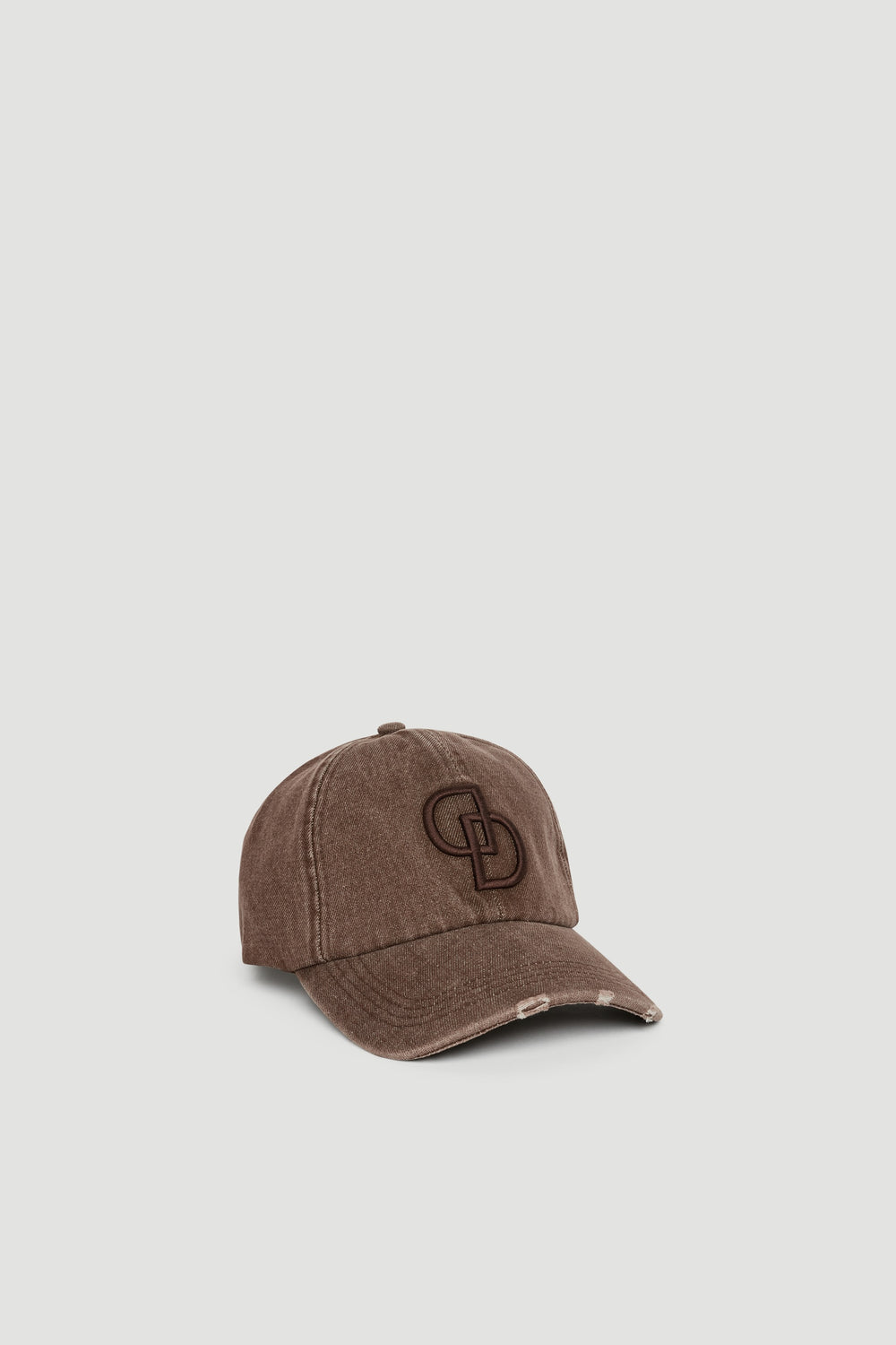 Distressed dark brown denim baseball cap with embroidered logo detail and curved brim on a neutral backdrop