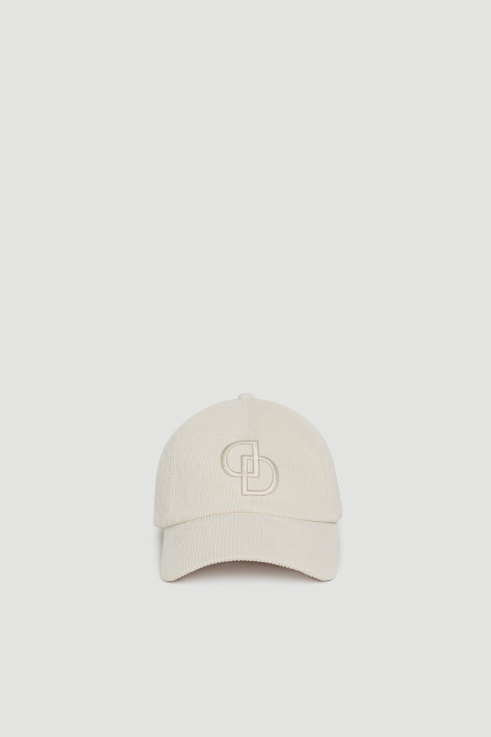 Cream-colored corduroy baseball cap with subtle embossed logo detail on front panel for a sleek finish