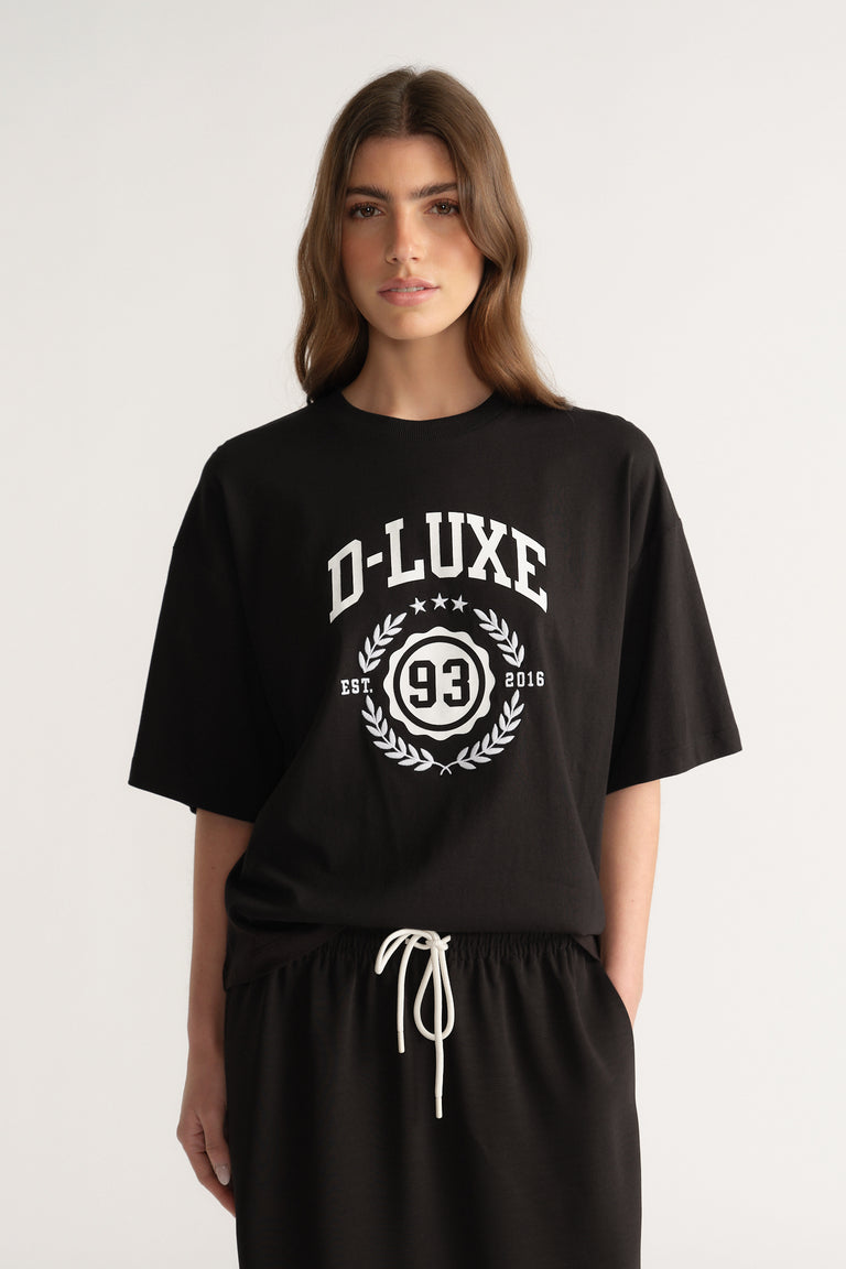 Woman wearing an oversized black graphic tee with matching black drawstring pants