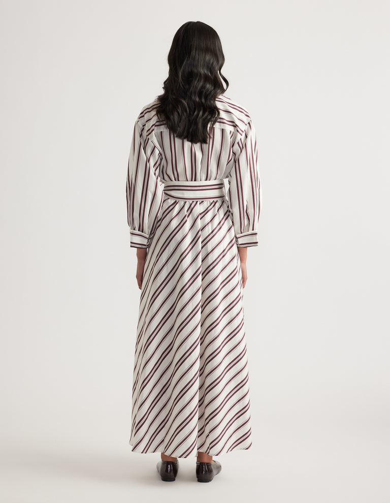 Woman viewed from behind in a striped long sleeve shirt dress with a collared neckline and tied waist
