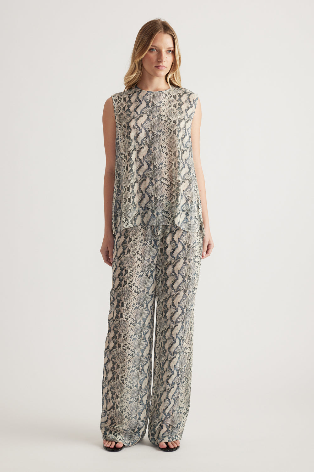Woman wearing a snakeskin print sleeveless high neck tank with matching wide leg pants