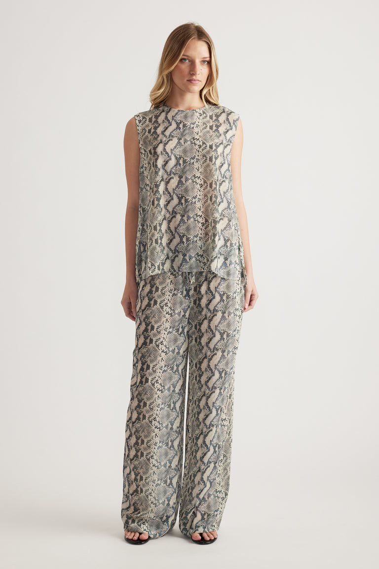 Woman wearing a snakeskin print sleeveless high neck tank with matching wide leg pants