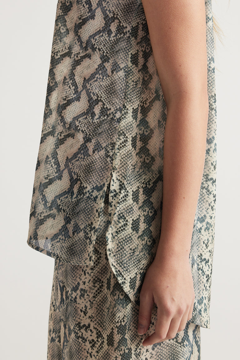 Woman wearing a snakeskin print sleeveless tank top with a draped side panel