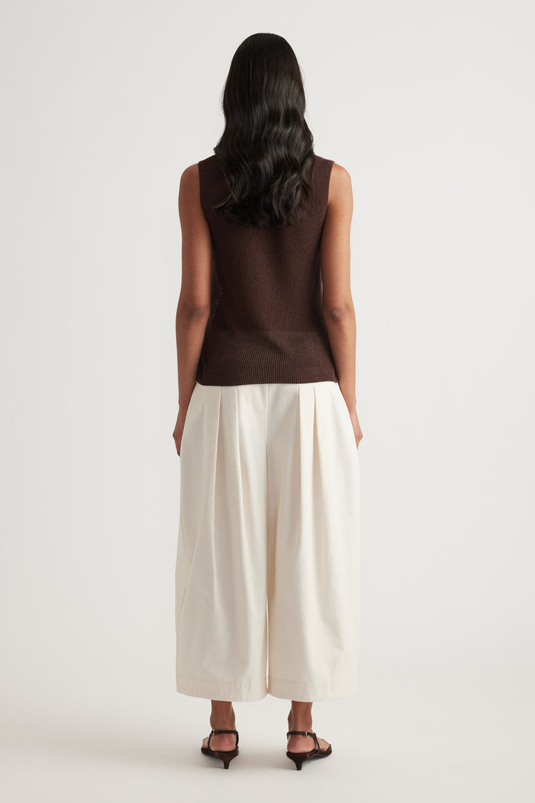 Back view of a model wearing a brown metallic knit tank with cream wide leg pants