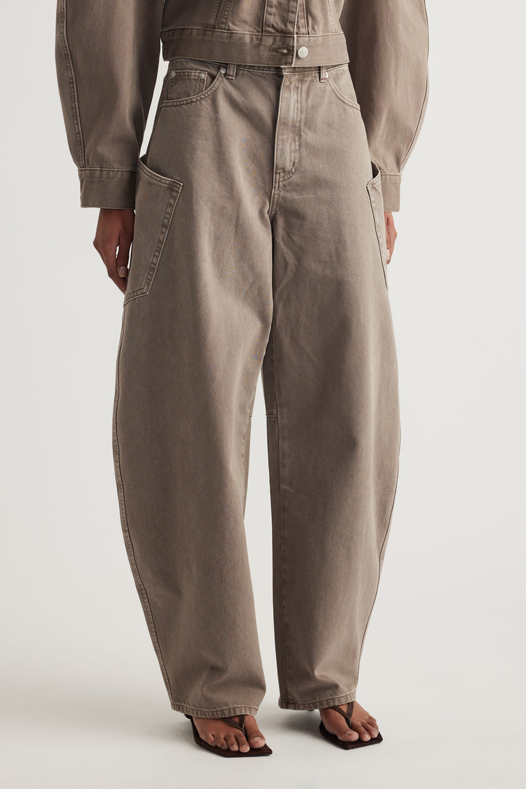 Woman wearing mushroom cargo barrel leg jeans with side pockets and black sandals