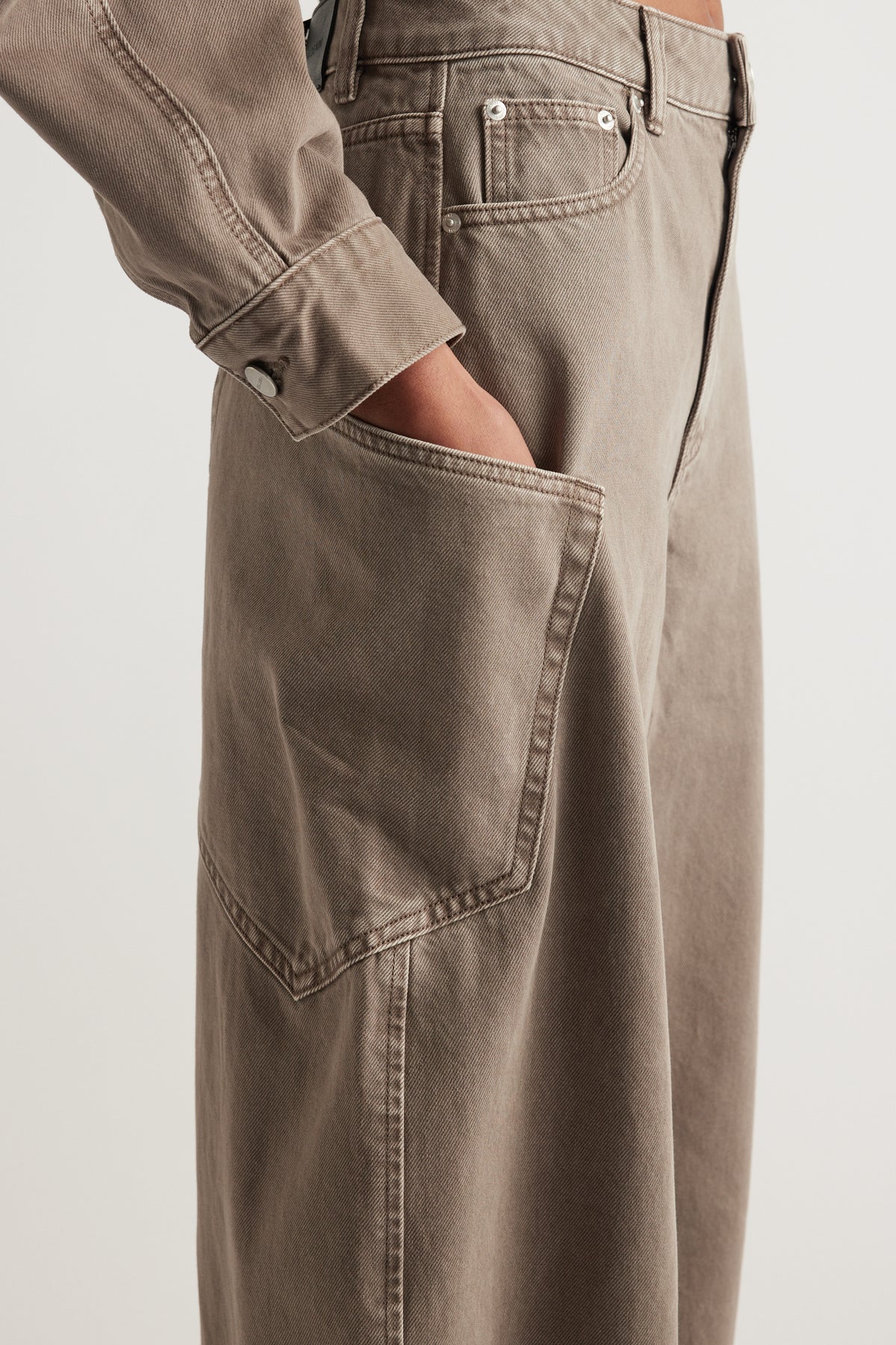Taupe high rise cargo barrel jeans with structured denim and a large side pocket