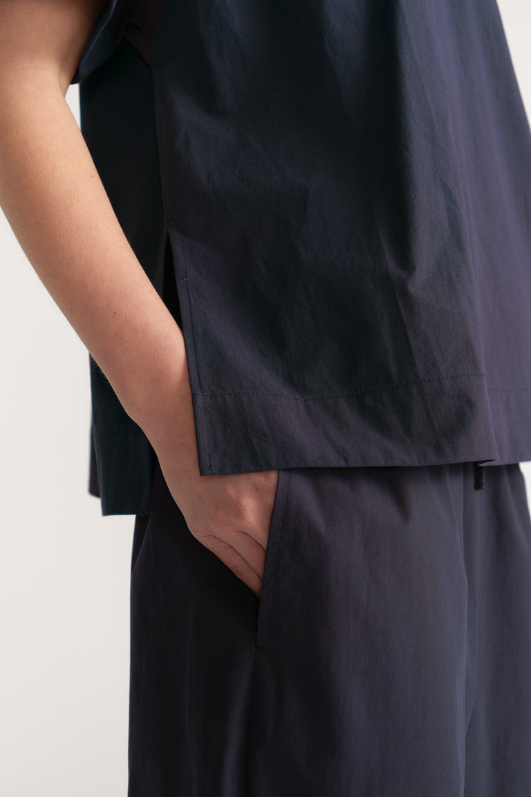 Woman wearing a dark navy boxy short sleeve top with matching relaxed pants