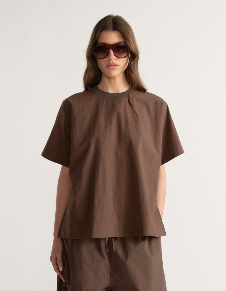 Woman wearing a brown oversized short sleeve top with matching pants and sunglasses