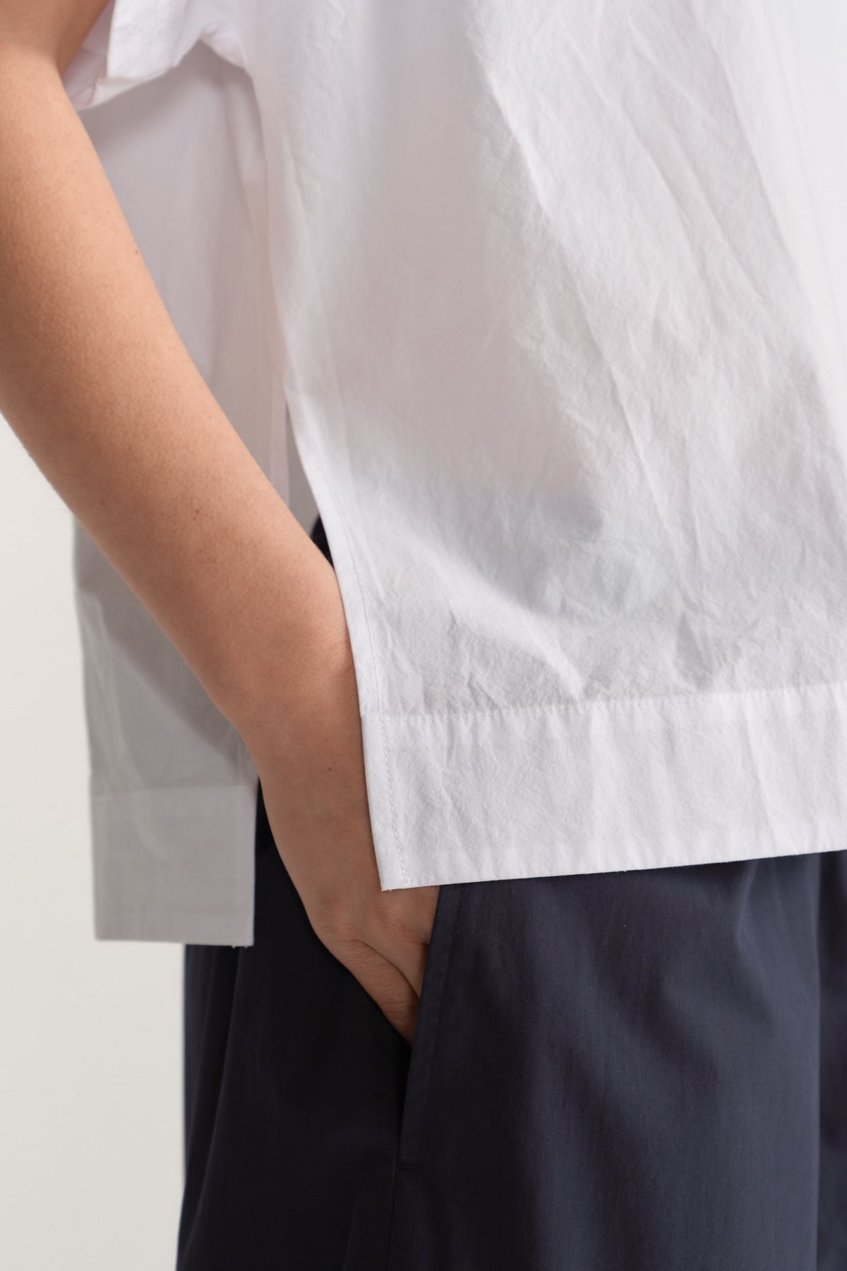 White relaxed fit short sleeve top paired with dark trousers