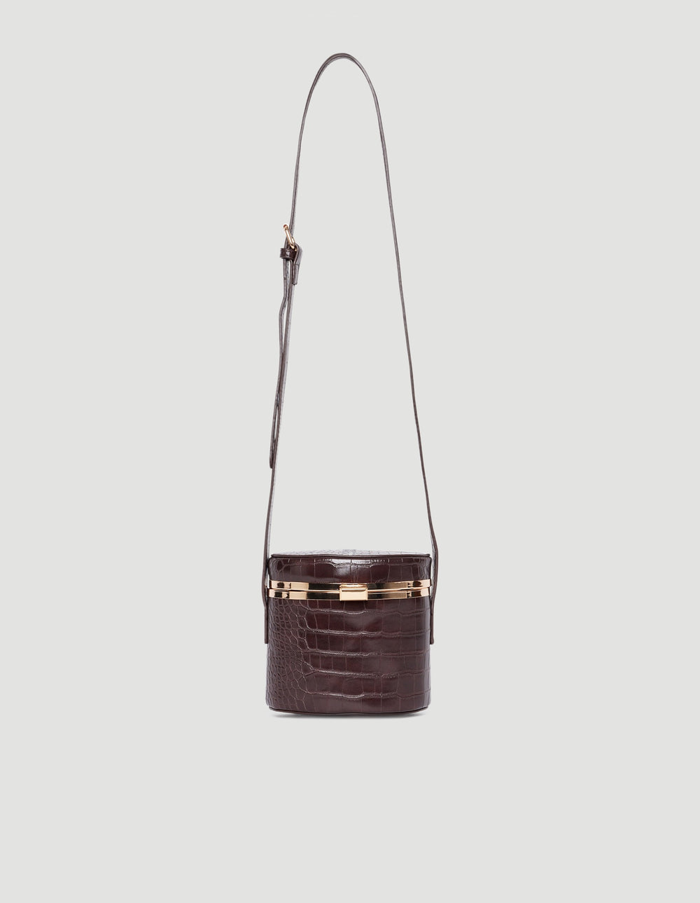 Dark brown croc-embossed crossbody bag with gold-tone hardware and adjustable long strap against a light background