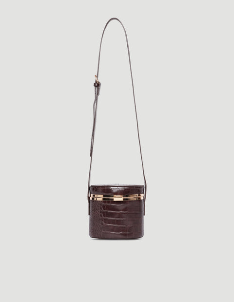 Dark brown croc-embossed crossbody bag with gold-tone hardware and adjustable long strap against a light background