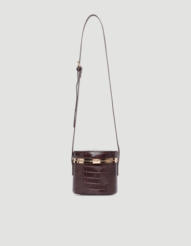 Dark brown croc-embossed crossbody bag with gold-tone hardware and adjustable long strap against a light background