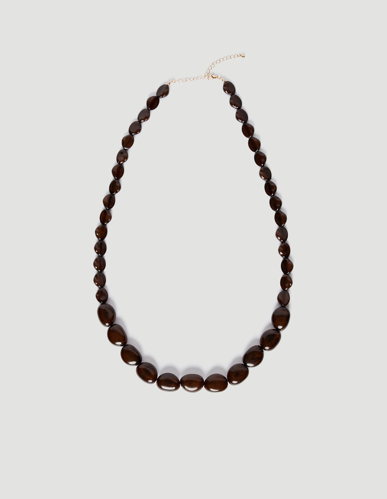 Long statement necklace featuring multi-sized dark resin beads with an adjustable gold-tone extension chain