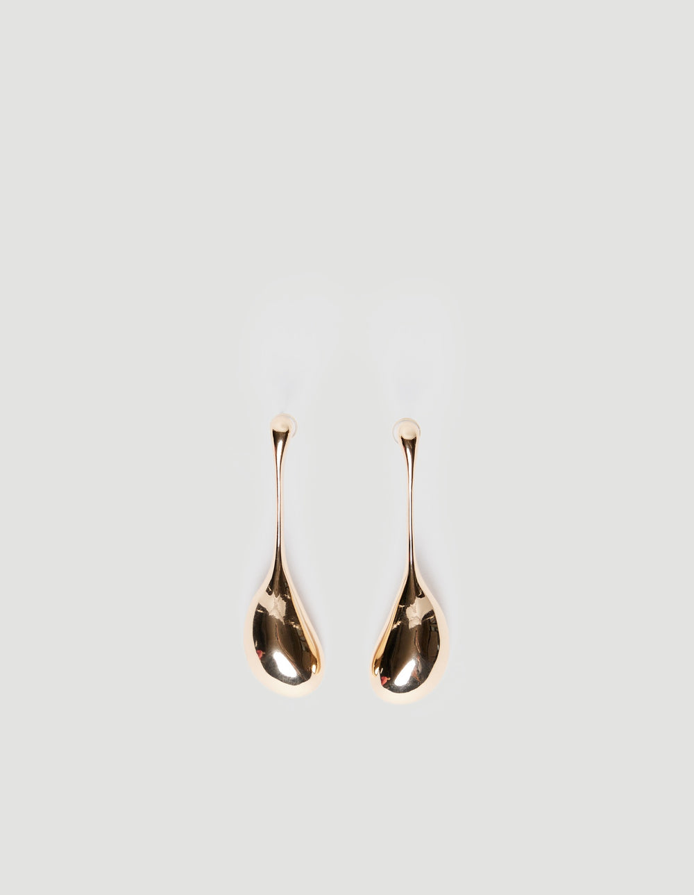 Pair of shiny gold teardrop-shaped earrings with stud backings on a plain light background