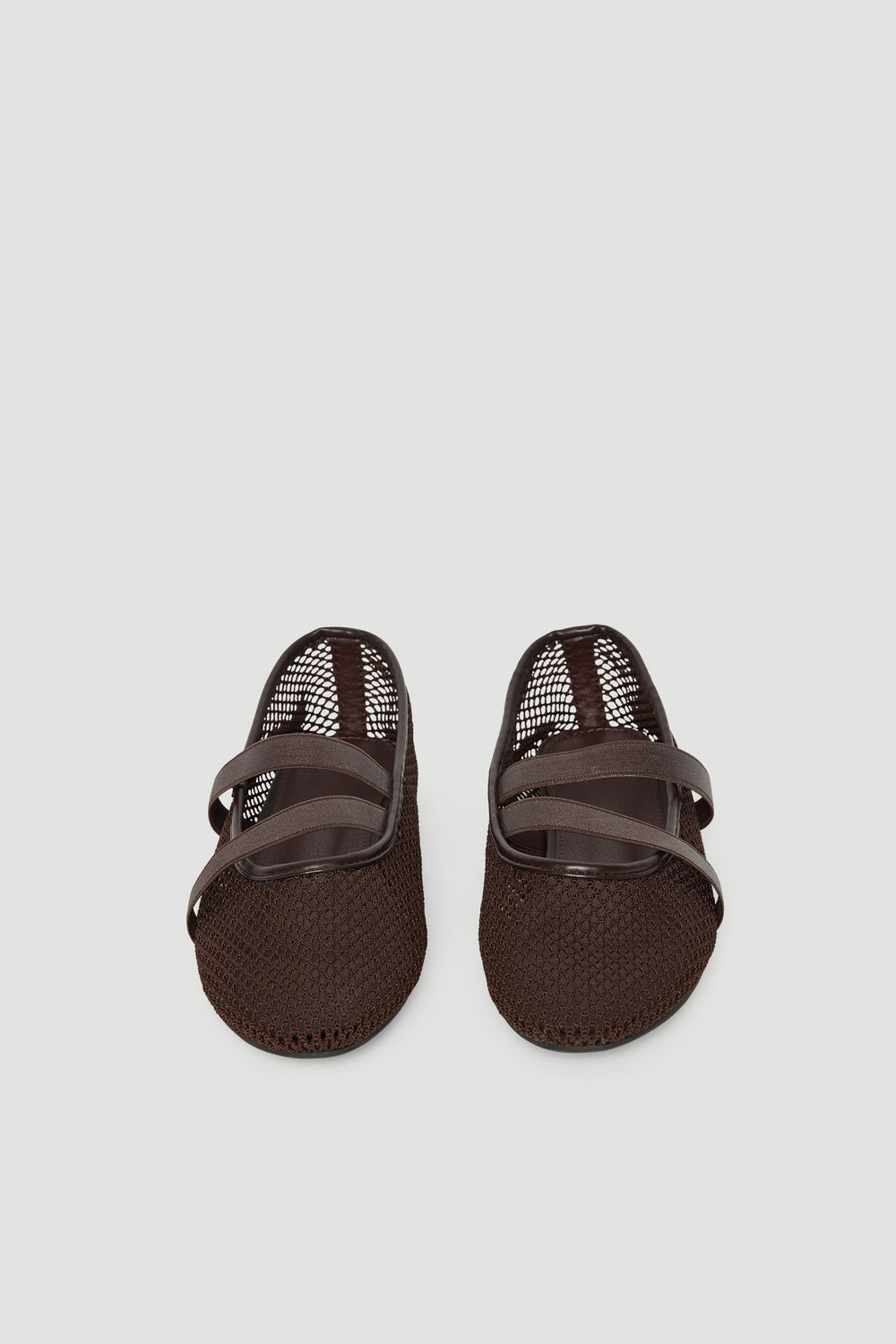 Dark brown ballet flats with breathable mesh upper and crossed elastic straps for a comfortable, sporty look.