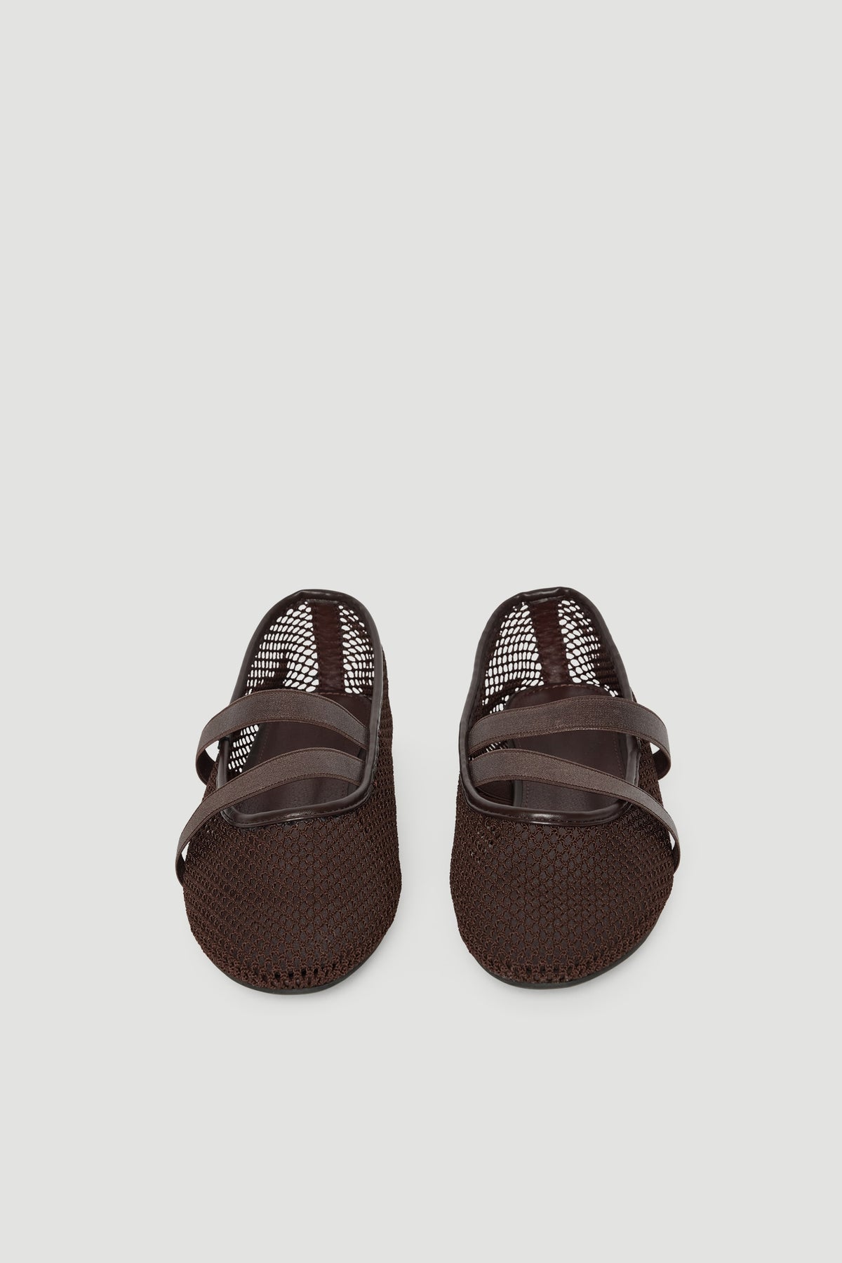Dark brown ballet flats with breathable mesh upper and crossed elastic straps for a comfortable, sporty look.