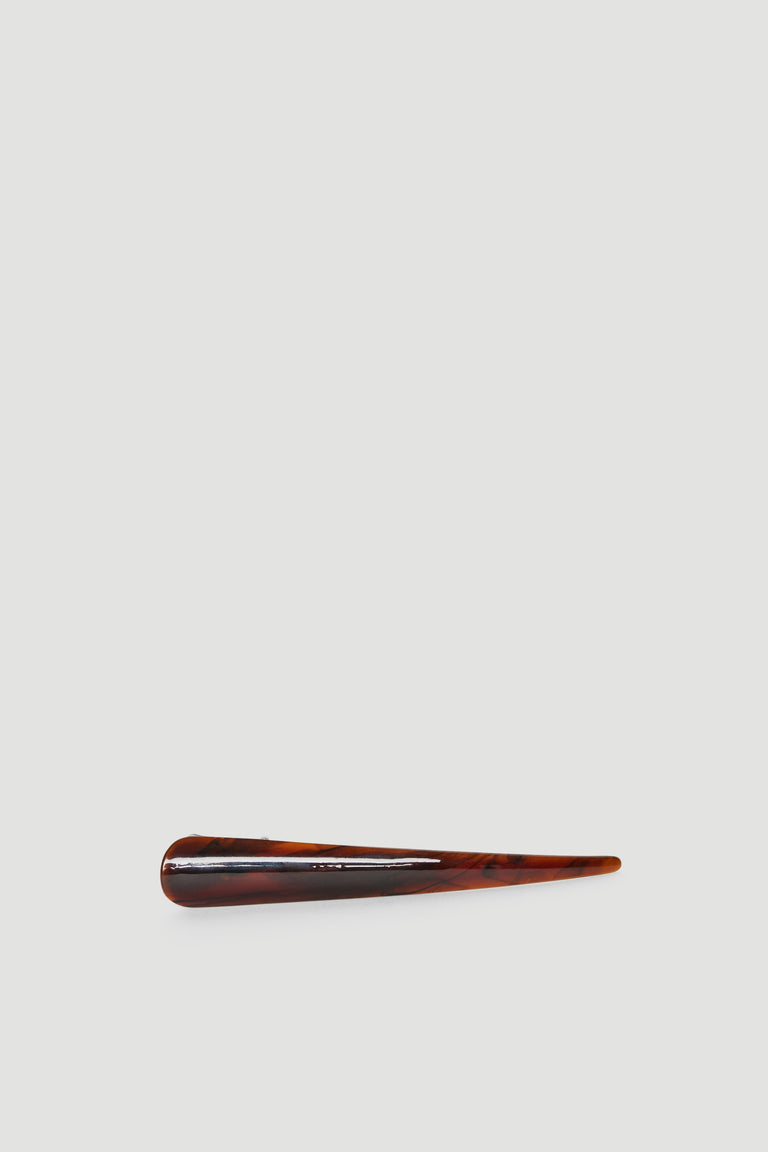 Sleek tortoiseshell tapered hair clip with glossy finish set against a minimal light grey background