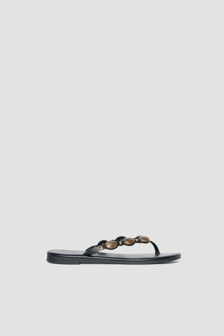 Black thong sandal with rounded gemstone embellishments across the strap and a flat footbed