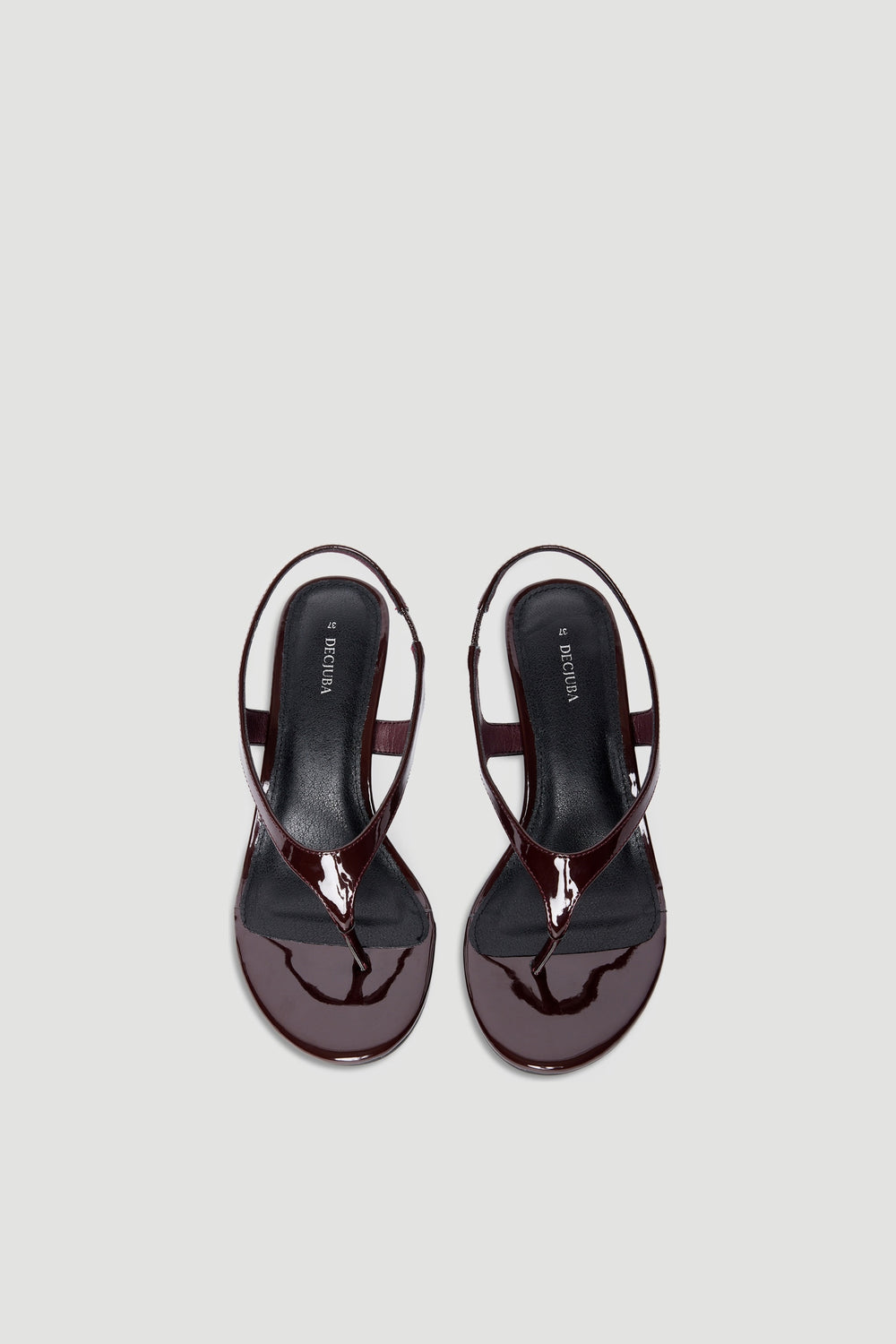 Glossy dark brown patent thong sandals with slingback strap and square toe on a light neutral background