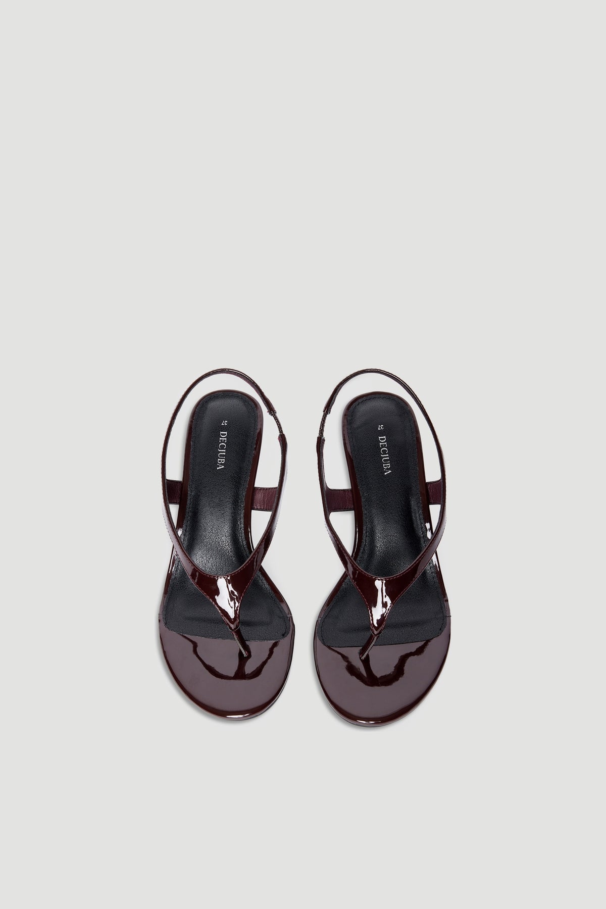 Glossy dark brown patent thong sandals with slingback strap and square toe on a light neutral background