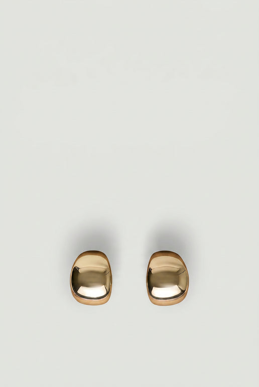 Pair of polished gold-tone statement hoop earrings with a smooth, modern rounded design on a neutral background
