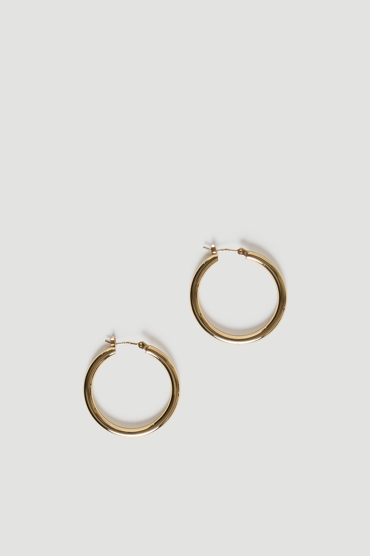 Pair of polished gold hoops with a smooth, rounded finish for versatile everyday style and effortless elegance.