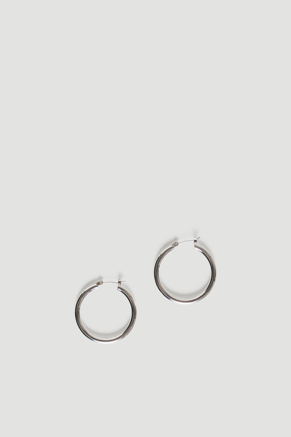 Minimalist pair of polished gold-tone hoops with a smooth finish, designed for everyday elegance and ease.