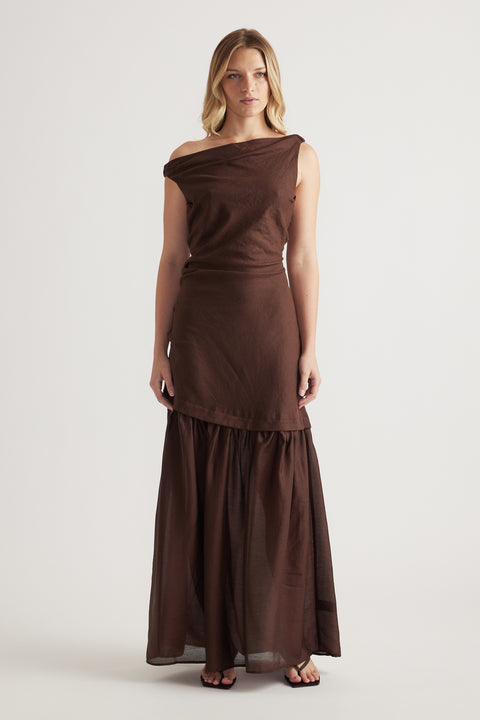 Woman wearing a brown off shoulder spliced maxi dress with a draped A line silhouette