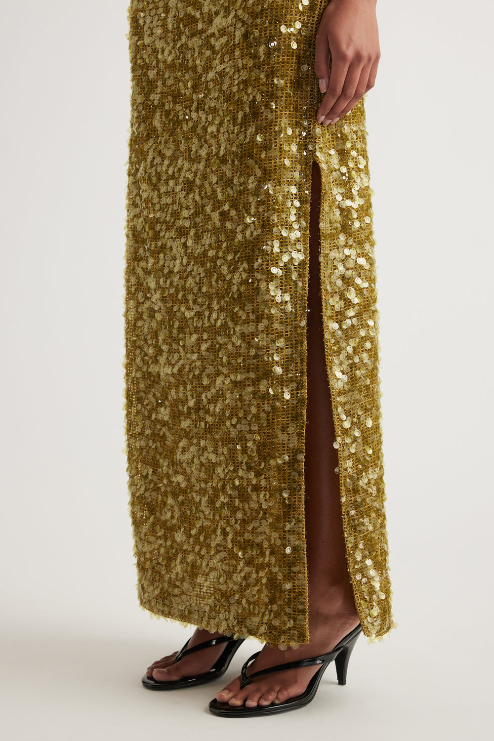 Gold sequin maxi dress with a high side split styled with black heeled sandals