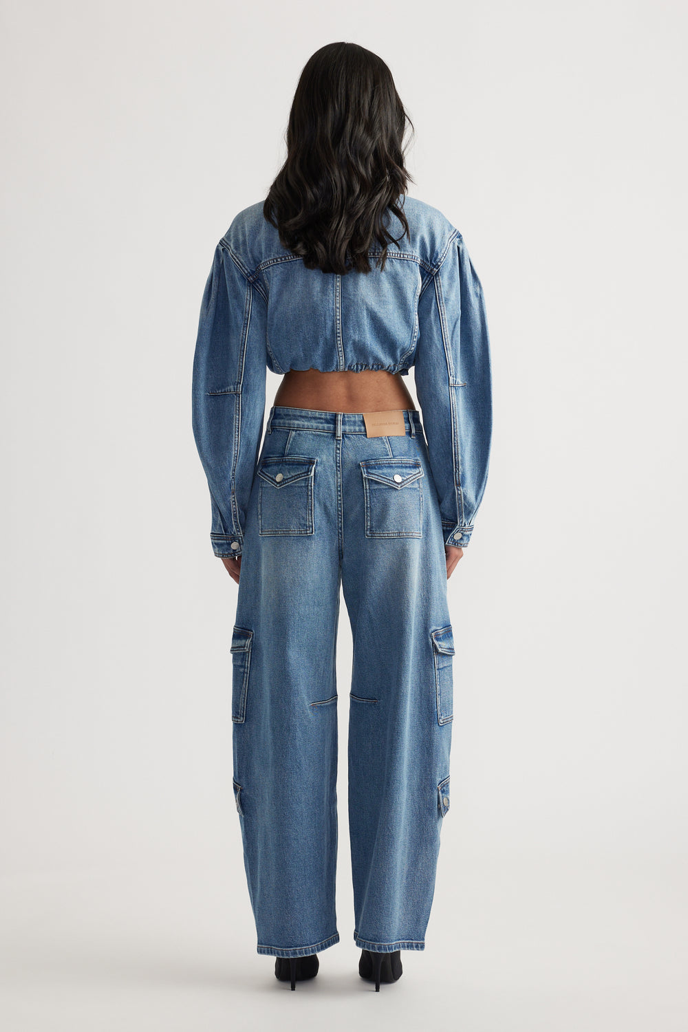 Woman wearing light blue wide-leg cargo jeans with multiple patch pockets paired with a cropped denim jacket