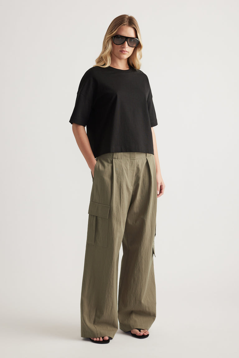 Woman wearing relaxed olive cargo pants with cargo pockets and a black tee
