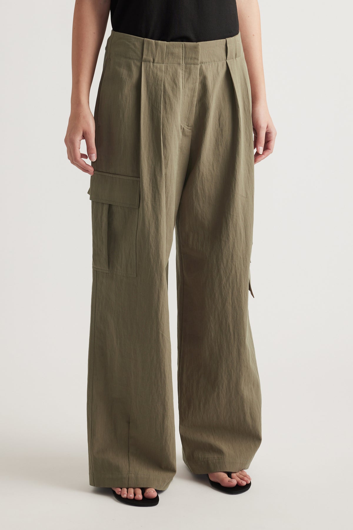 Model wearing olive green relaxed fit cargo pants with cargo pockets and full length legs