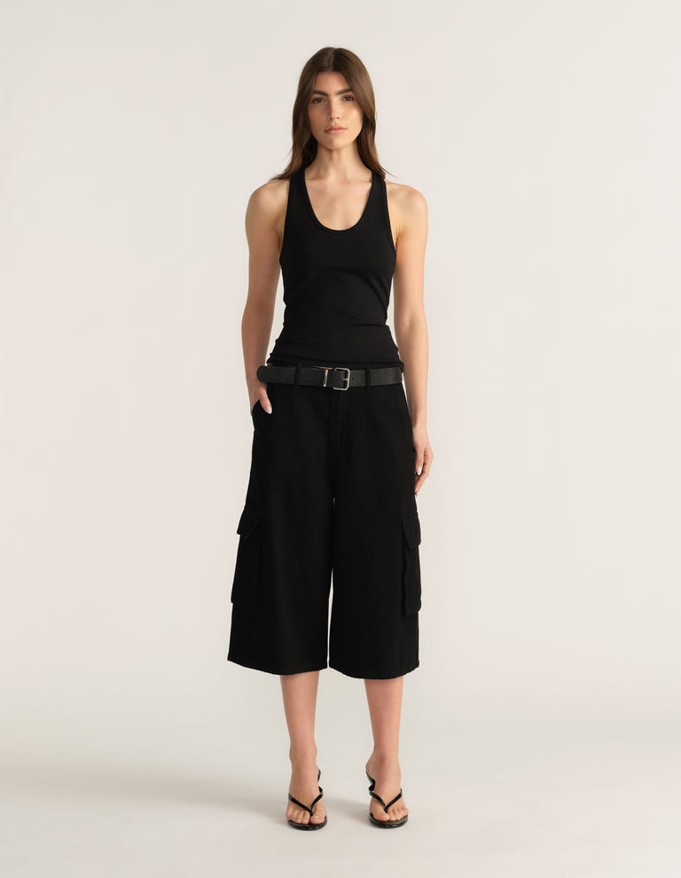 Model wearing black cargo shorts with a tank top, belt and strappy sandals