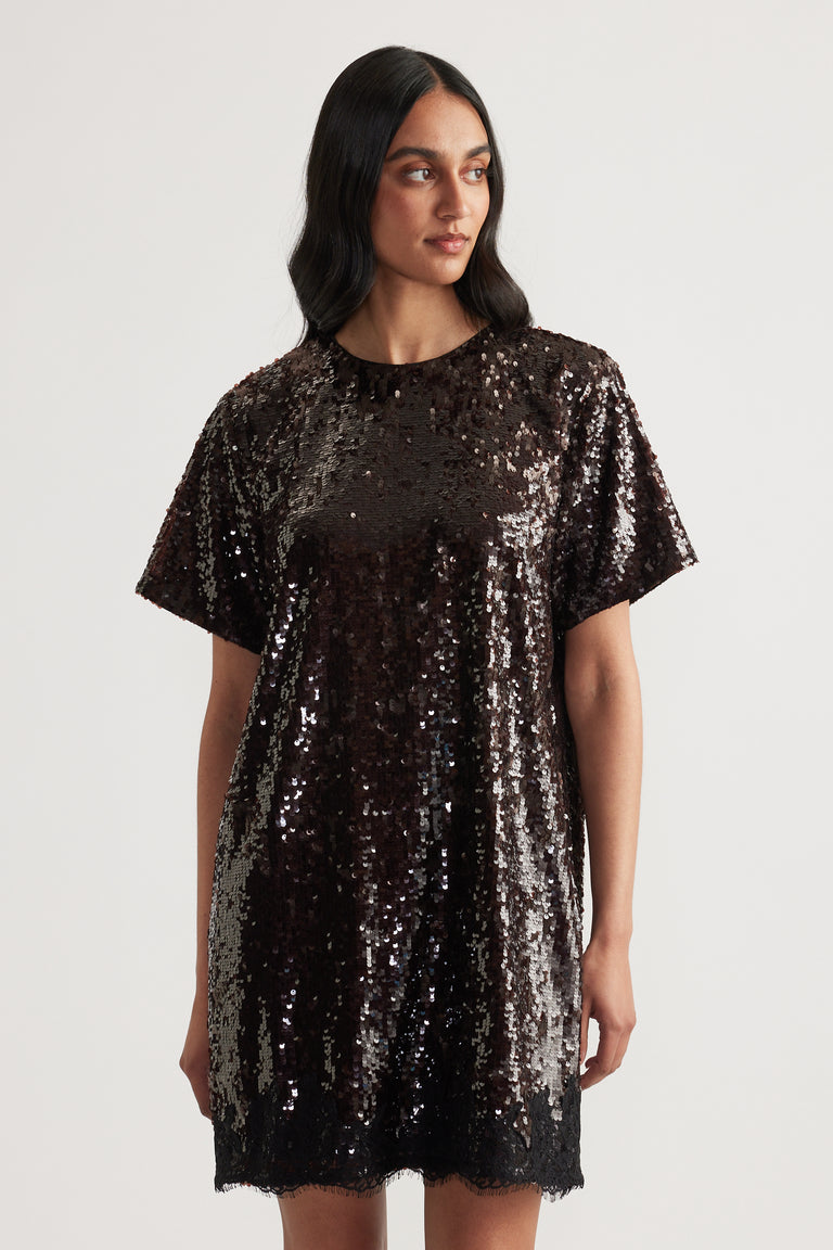 Woman wearing a black sequin mini dress with short sleeves, a crew neck and relaxed fit