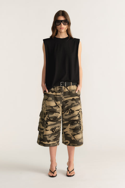 Woman wearing a black sleeveless top and camouflage cargo shorts with sunglasses
