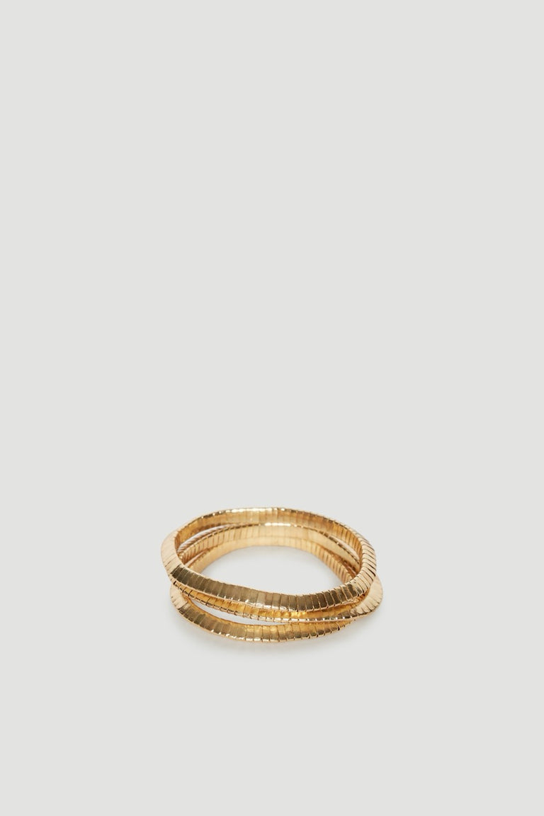 Three shiny gold stretch bracelets stacked together in a textured layered design