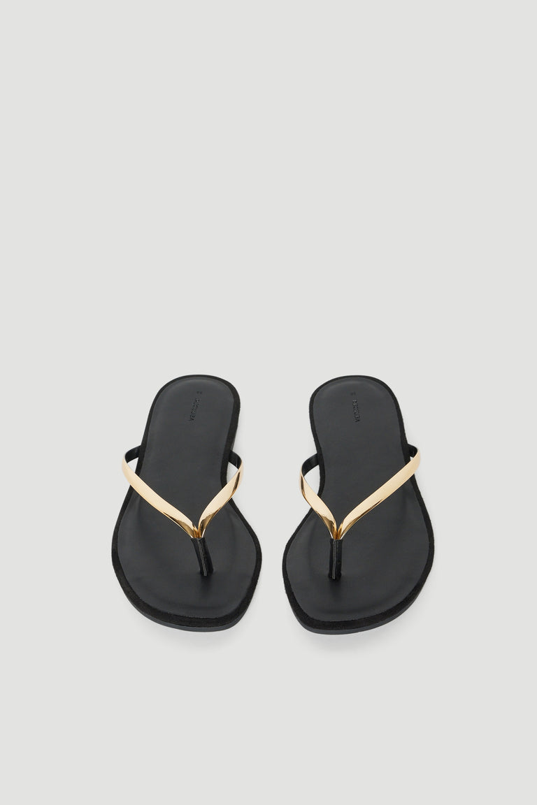 Pair of black thong sandals with thin high shine gold straps and padded footbeds