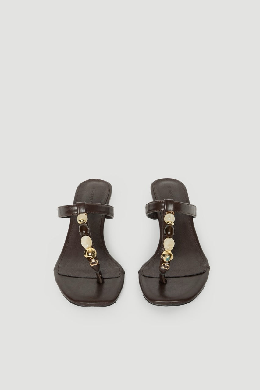 Pair of dark brown thong heels with thin straps, colourful gemstones and gold hardware
