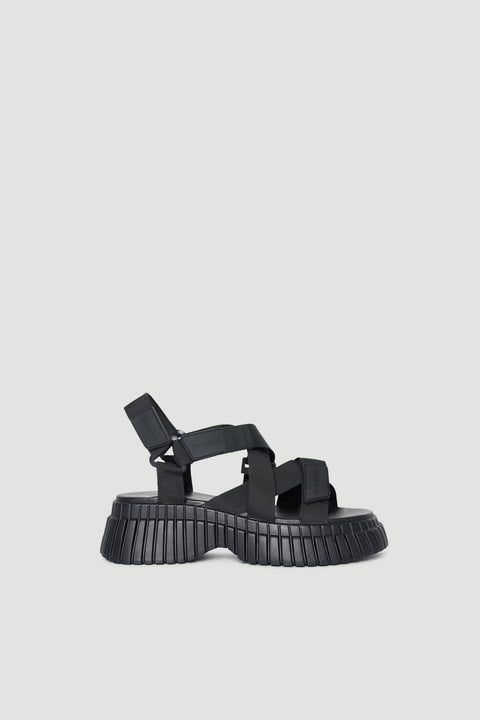 Black platform sandals with chunky ridged soles, open toes and adjustable hook and loop straps