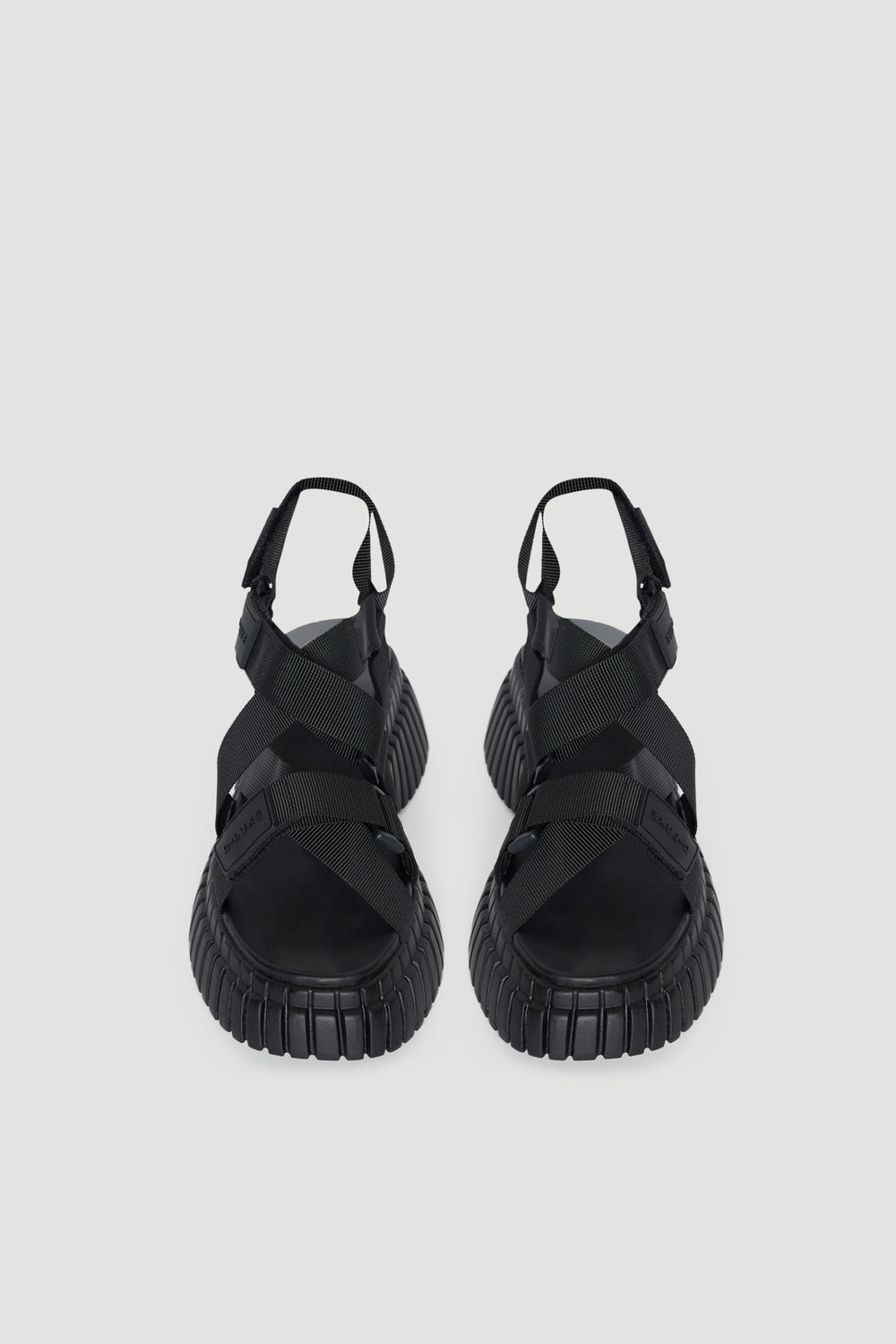 Pair of black platform sandals with chunky soles, open toes and adjustable hook and loop straps