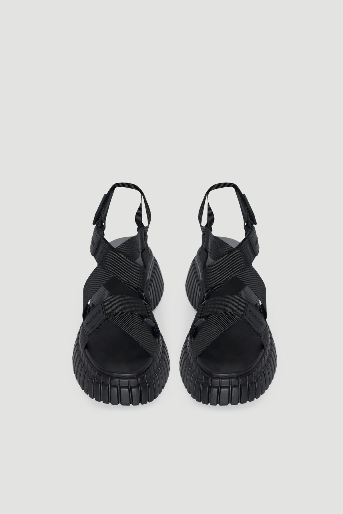Pair of black platform sandals with chunky soles, open toes and adjustable hook and loop straps