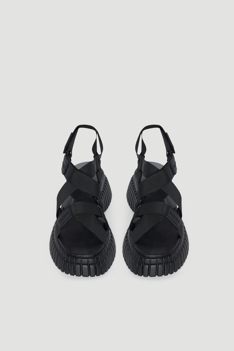 Pair of black platform sandals with chunky soles, open toes and adjustable hook and loop straps