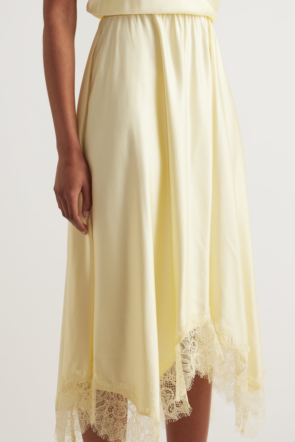 Cream midi dress with an A line silhouette and delicate lace trim at the hem