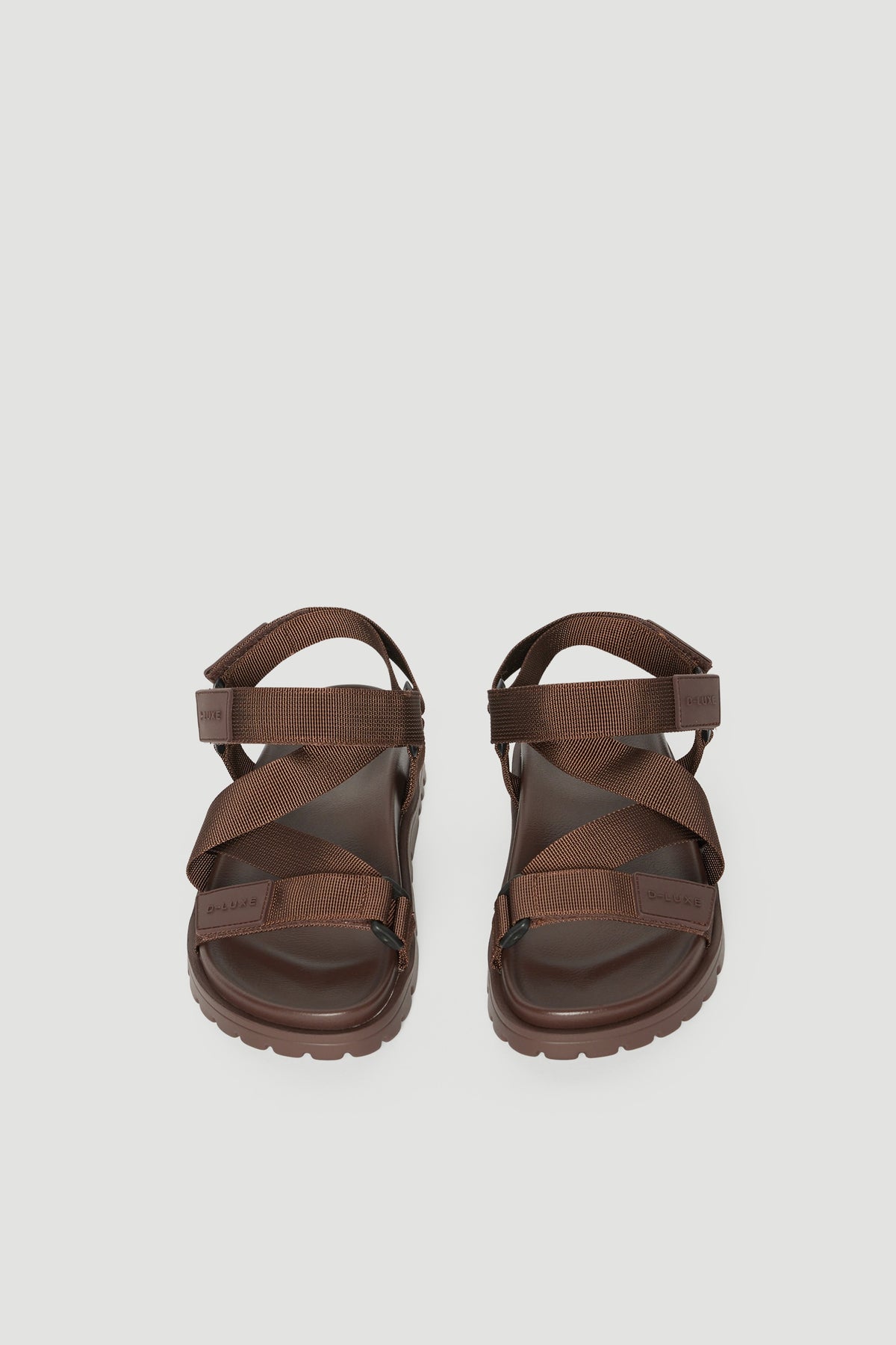 Pair of brown crossover strap sandals with padded soles and adjustable back straps