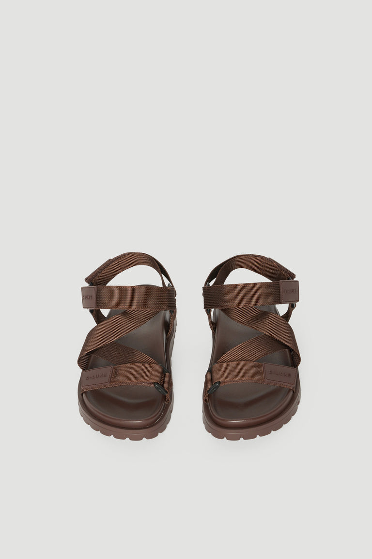 Pair of brown crossover strap sandals with padded soles and adjustable back straps
