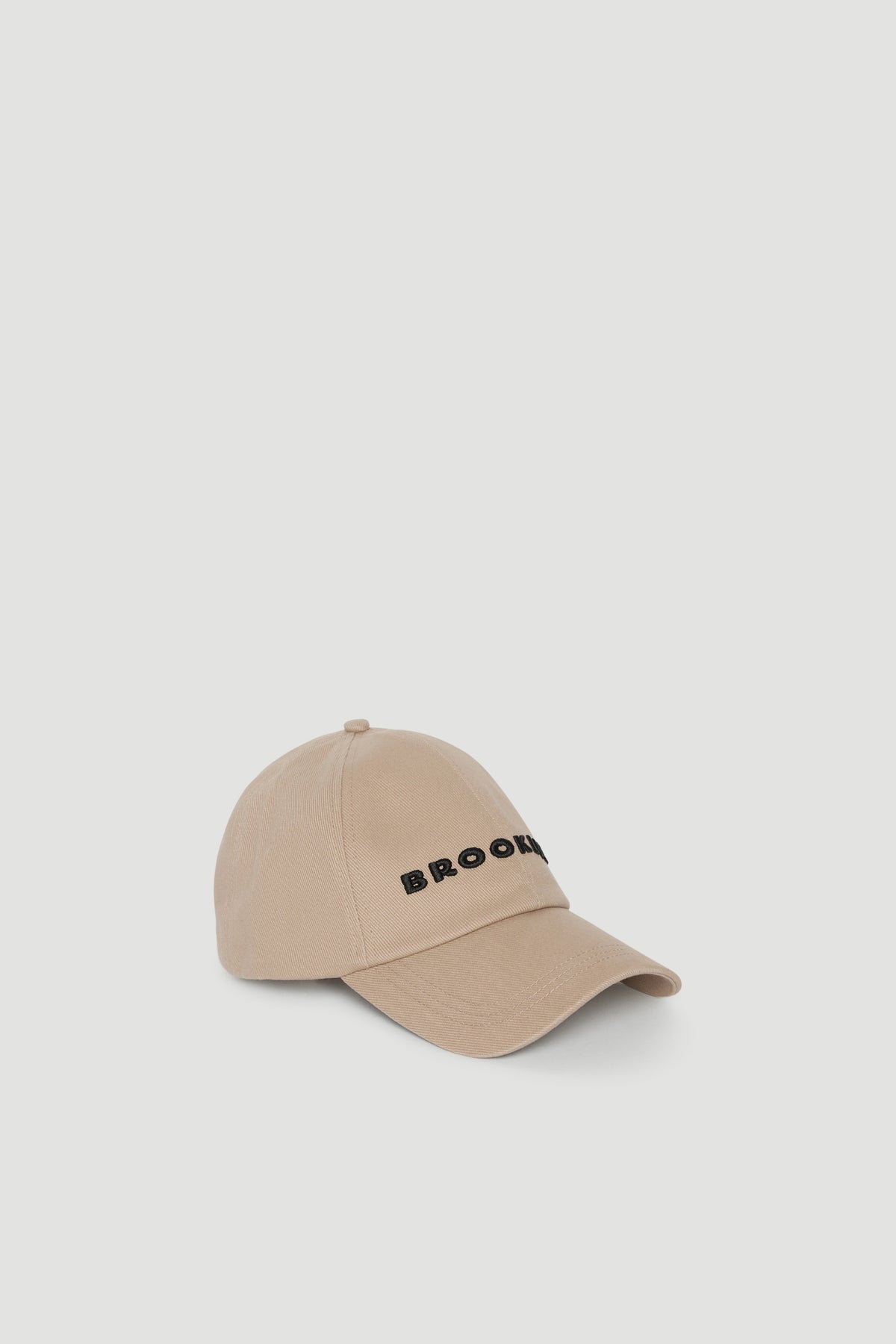 Beige baseball cap with embroidered black logo and curved brim