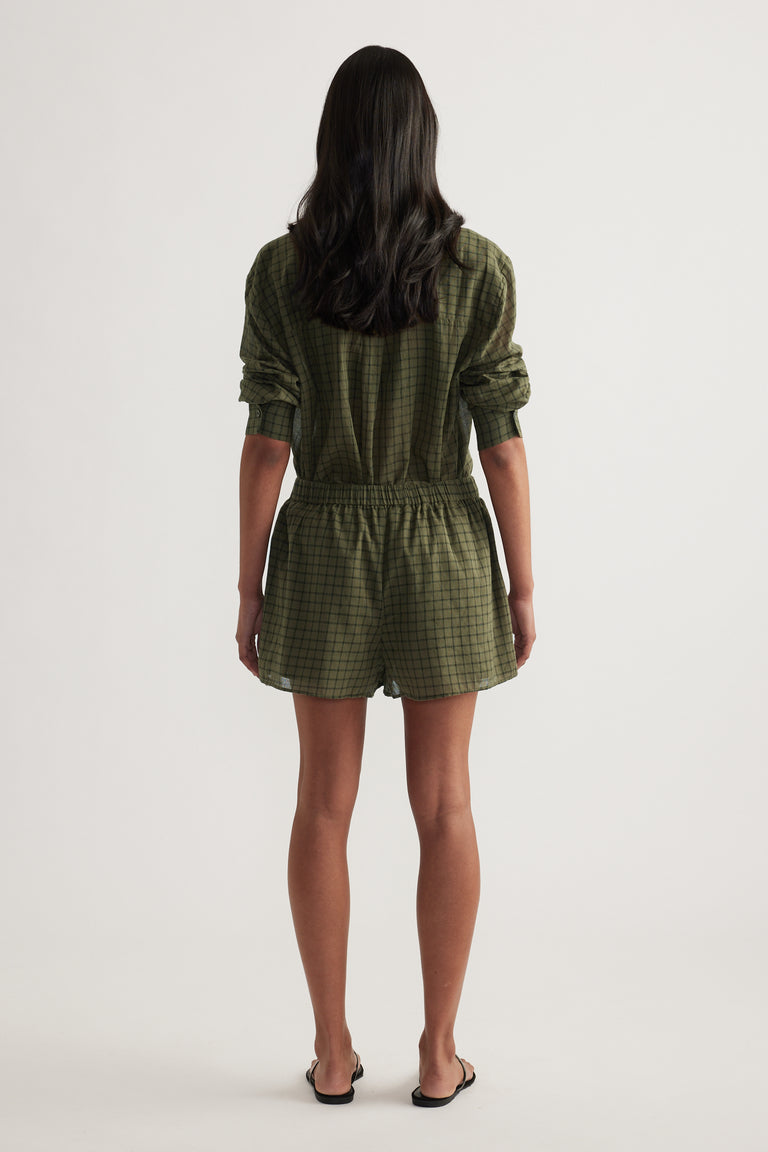 Back view of a model wearing green checked shorts with an elasticated waist and matching shirt