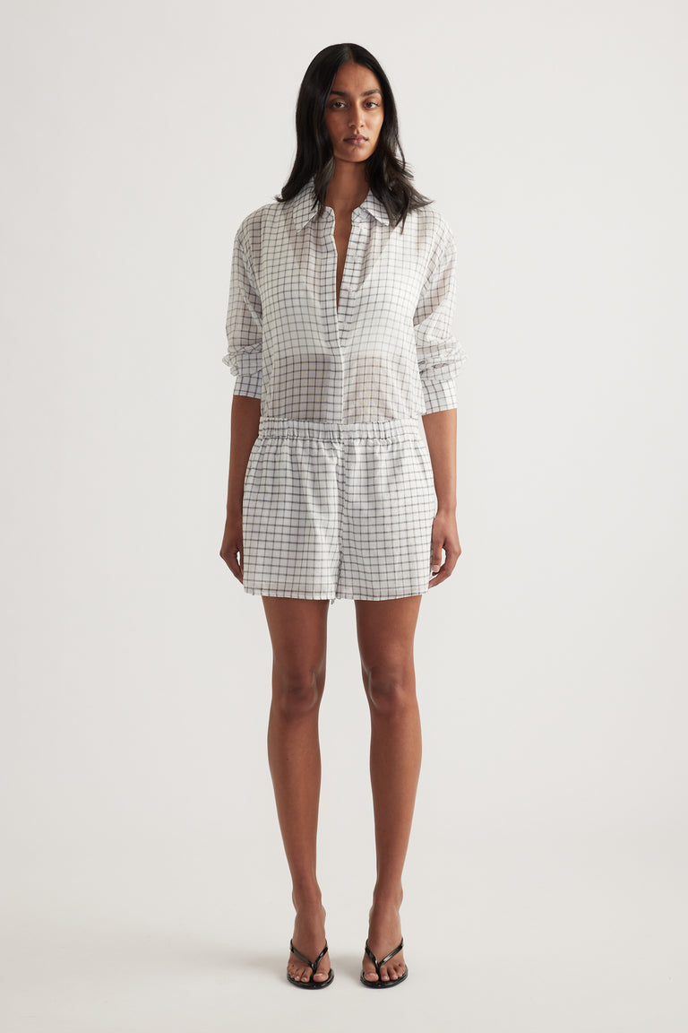 Model wearing a checked blouse with matching wide-leg shorts and strappy sandals